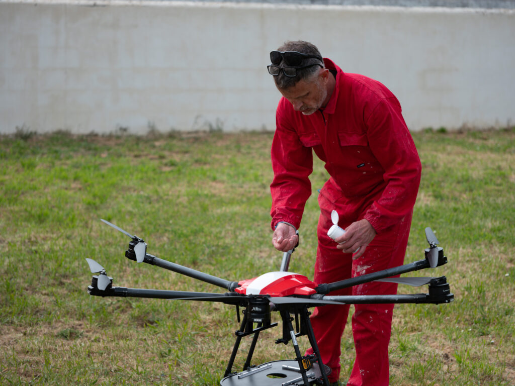 Photographie d'un opérateur entrain de passer du talque sur le drone après emploi